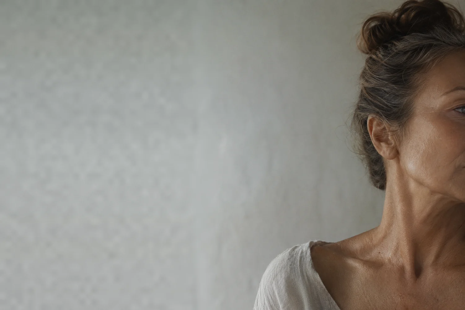 Mulher adulta de perfil em luz natural, com foco na pele do pescoço e do colo, tema do bioestimulador de colágeno, Dra. Helena Ciacci em Varginha e Campo Belo